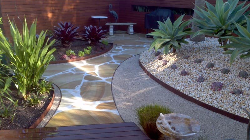 Ryde District Sydney landscape with curved flagstone path, pebble bed, and agave planting by Nazscapes